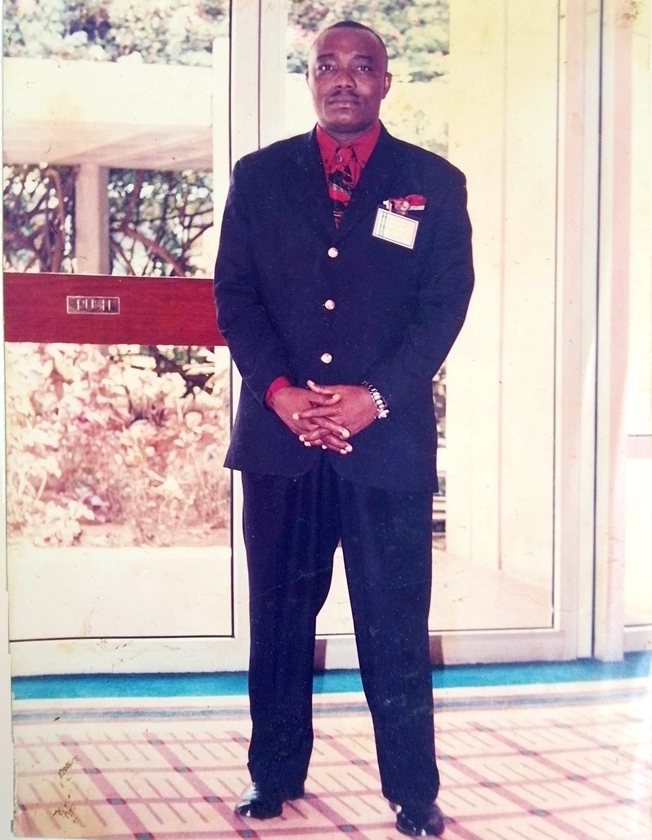 Apostle Prosper standing in black suit